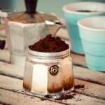 Moka del caffè con filtro sporco, spillo per la pulizia in primo piano.